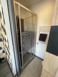 uma porta de duche em vidro num quarto em Studio petit plus gaming ! em Calais