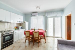 uma cozinha com mesa e cadeiras num quarto em Apartments with a parking space Brsec, Opatija - 7796 em Martina