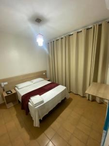 una camera con letto in una stanza con tende di Hotel Novo México a Guarulhos