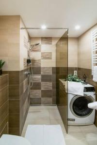 een badkamer met een douche en een wasmachine bij Old Town Apartment in Vilnius