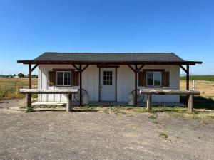 a small house with two benches in front of it at Adorable One Bedroom Cottage in Oakdale