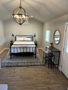 een slaapkamer met een bed, een tafel en een kroonluchter bij Adorable One Bedroom Cottage in Oakdale