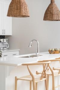 a kitchen with a sink and rattan pendant lights at Serene Boho Chic Home-Mins to DT in Nashville