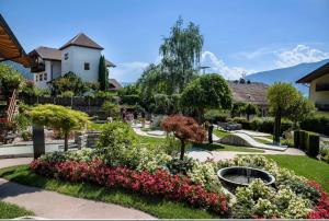 un giardino con fiori rosa e bianchi in un cortile di Hotel Garni Lichtenau a Scena