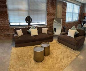 a living room with two couches and two tables at Luxury Cozy Loft Downtown STL in Saint Louis