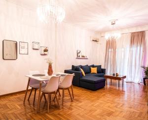 a living room with a blue couch and a table at Lilly's House in Volos