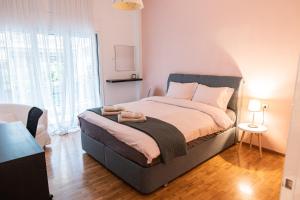 a bedroom with a bed and a large window at Lilly's House in Volos