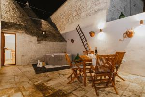 a room with a table and chairs and a bed at MILESTONES MODERN SUITE TRULLO - Jacuzzi Spa & Relax in Alberobello +42 photos