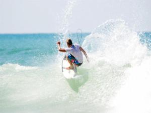 un hombre montando una ola en una tabla de surf en el océano en Appartement Seignosse, 1 pièce, 2 personnes - FR-1-239-437, en Seignosse