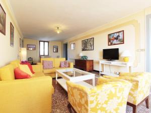 sala de estar con muebles de color amarillo y TV en Charming apartment in Santa Giustina with shared swimming pool en Santa Giustina