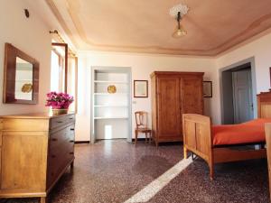 a bedroom with a bed and a dresser and a chair at Spacious apartment in Santa Giustina with shared swimming pool in Santa Giustina