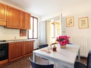 a kitchen with a table with flowers on it at Spacious apartment in Santa Giustina with shared swimming pool in Santa Giustina