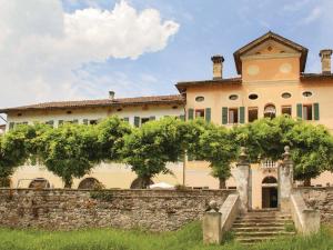 a large house with a stone wall and stairs at Spacious apartment in Santa Giustina with shared swimming pool in Santa Giustina