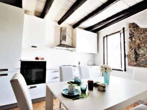 a white kitchen with a white table and chairs at Scenic apartment in Santa Giustina with shared garden in Santa Giustina