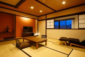 a living room with a table and a couch at Hokuriku Yamashiro Onsen Hotel Kikyou in Yamashiro