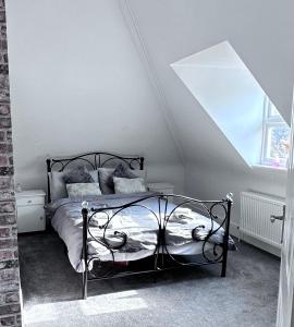 ein Schlafzimmer mit einem schwarzen Bett im Dachgeschoss in der Unterkunft Lancaster Heights in Woodhall Spa