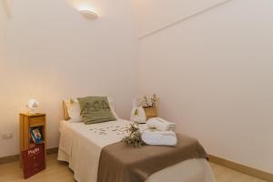 una camera da letto con un letto e asciugamani di Milestones Modern Suite Trullo Jacuzzi Spa & Relax ad Alberobello