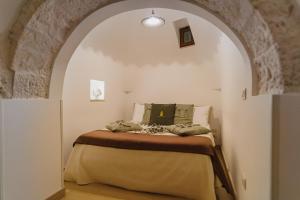una camera con letto ad arco di Milestones Modern Suite Trullo Jacuzzi Spa & Relax ad Alberobello
