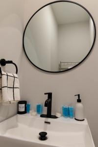 lavabo con espejo redondo encima en Cozy 2 bedroom condo, en Princeton