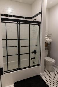 La salle de bains est pourvue d'une porte de douche en verre et de toilettes. dans l'établissement Cozy 2 bedroom condo, à Princeton