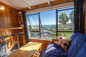 a room with a large window with a couch and a table at Palm Beach - SupaCute Cottage, Sky TV, Wifi and possibly a Car in Palm Beach