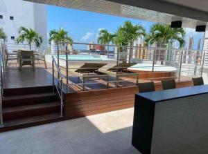 uma varanda com uma mesa e uma piscina num edifício em Flat encantador no Manaira Apart Hotel 1301 em João Pessoa