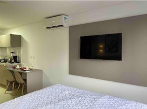 um quarto com uma cama e uma cozinha com uma mesa em Flat encantador no Manaira Apart Hotel 1301 em João Pessoa