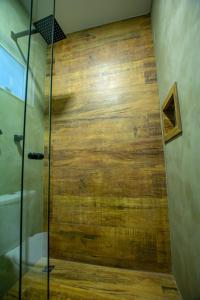um chuveiro com uma porta de madeira na casa de banho em Chakras Pousada em Jaguariaíva