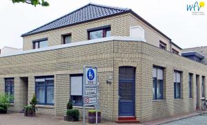 a brick building with a sign in front of it at Stine's Hus Ferienwohnung 1 in Borkum +10 photos