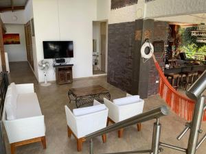 a living room with white chairs and a tv at Casa Paraiso del Lago in Prado