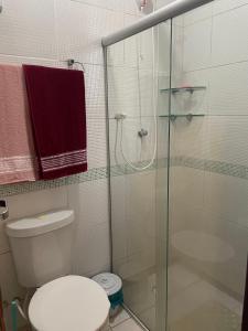 a bathroom with a toilet and a glass shower at Winterville 618 Flat Gravatá in Gravatá