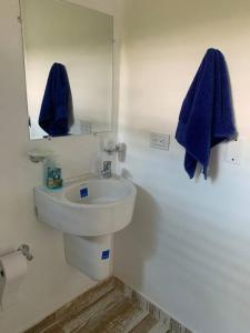 Baño blanco con lavabo y espejo en Casa Paraiso del Lago en Prado