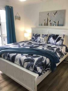 a bed with a blue and white blanket on it at Anchors Away at Innes Park Opp Park & Beach dogs welcome inside in Pemberton
