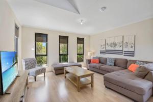 a living room with a couch and a flat screen tv at Blue Lagoon Coastal Retreat - Falmouth in Falmouth