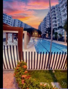 a pool with a fence and some flowers and buildings at Hermoso Apartamento Ricaurte Peñazul La Morada. in Ricaurte