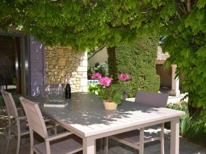 ヴェゾン・ラ・ロメーヌにあるHoliday home with garden and private poolのワイン1本と花のテーブル