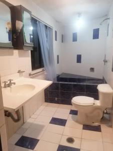 a bathroom with a toilet and a sink at Casa con vista y alberca privada in Acapulco
