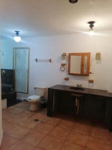 een badkamer met een toilet, een wastafel en een spiegel bij Casa con vista y alberca privada in Acapulco