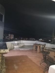 a rooftop patio at night with tables and chairs at Casa con vista y alberca privada in Acapulco