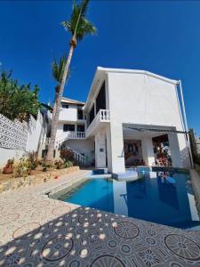 een huis met een zwembad en een palmboom bij Casa con vista y alberca privada in Acapulco