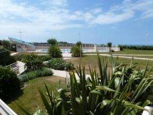 - une vue sur un parc avec un bâtiment en arrière-plan dans l'établissement Appartement Les Sables-d'Olonne, 2 pièces, 4 personnes - FR-1-197-154, à Les Sables-dʼOlonne