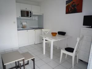 La Pironnière的住宿－Appartement Les Sables-d'Olonne, 2 pièces, 4 personnes - FR-1-92-740，白色的厨房配有白色的桌子和椅子