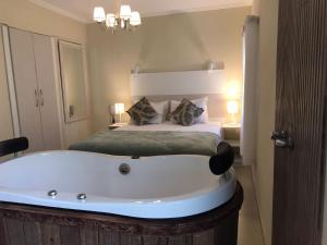 um quarto com uma grande banheira em frente a uma cama em Pousada Quinta dos Doges em Valença