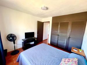 a bedroom with a bed and a fan and a television at beautiful apartment with the best location in Puerto Vallarta