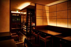 a restaurant with a table and chairs and a wine cellar at The Rise Osaka Kitashinchi in Osaka