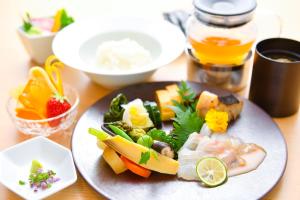 a plate of food with vegetables and fruit on a table at The Rise Osaka Kitashinchi in Osaka