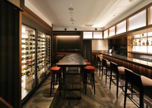 a bar with a table and stools in a restaurant at The Rise Osaka Kitashinchi in Osaka