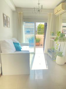 um quarto branco com uma cama e uma grande janela em Departamento TANGO - Céntrico - Balcón - Zona Cardiológico em Corrientes