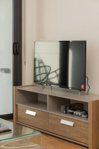 a flat screen tv sitting on top of a wooden entertainment center at Prime Location Compact 1BD Apartment at Southbank in Brisbane