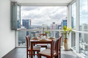 a dining room with a table and chairs and a large window at Phenomenal City View Central Location 2BD Apart in Brisbane